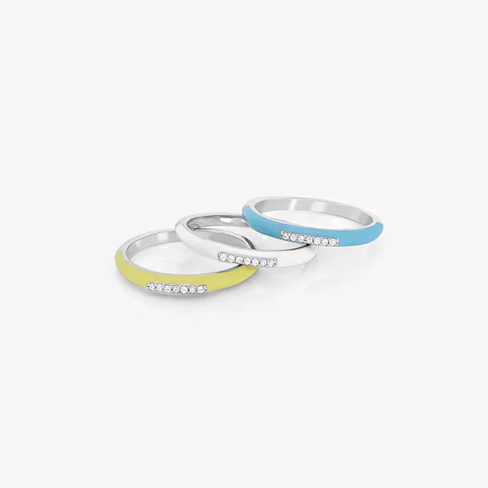 A set of three stack rings in silver, blue, and yellow colors, each featuring a band adorned with cubic zirconia stones.
